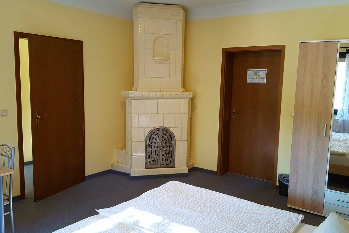 Une pièce avec une cheminée, un lit, une armoire et une table à manger avec des chaises.