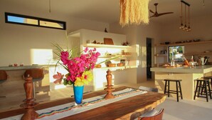 Une cuisine moderne avec un îlot central, des chaises en bois et un luminaire suspendu.