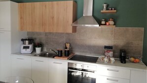 A modern kitchen with white cabinets, a stainless steel stove, and a built-in oven.