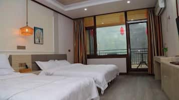 A hotel room with two beds, a wooden ceiling, a large window with curtains, and a balcony.