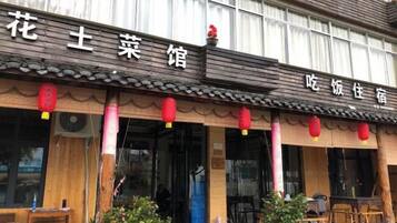 A traditional building with a sign that reads 'flower vegetable restaurant' and 'snack restaurant'.