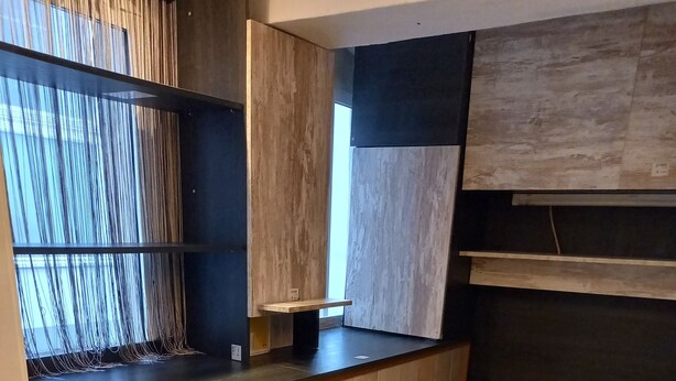 Une cuisine compacte avec des meubles en bois, un banc intégré et un petit coin salon.