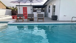 A swimming pool with a patio area featuring a grill and outdoor seating. - Desert Oasis near Downtown Las Vegas (Las Vegas)