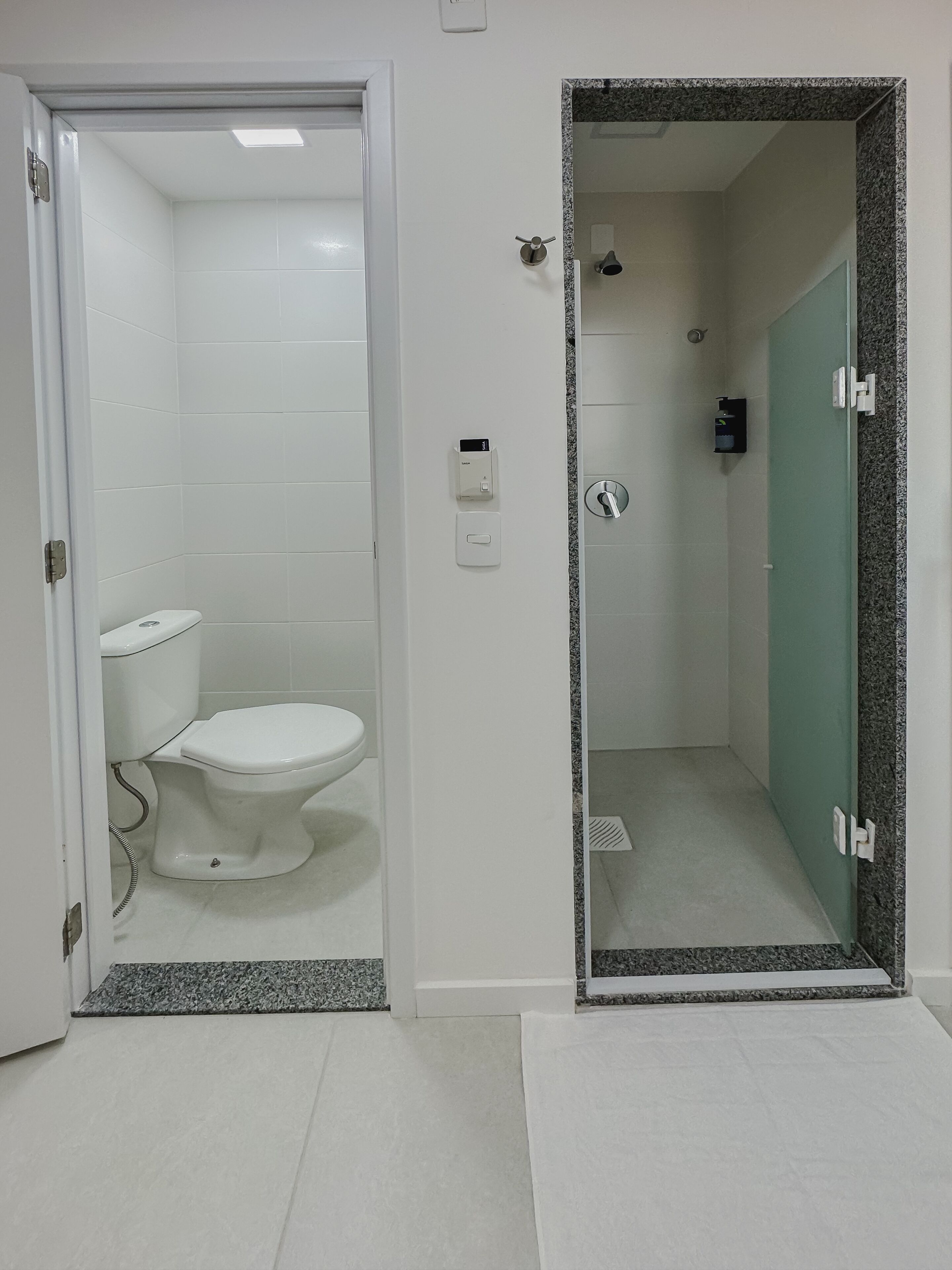Un baño con inodoro, ducha y espejo.