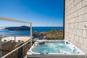 Un bain à remous avec vue sur la mer et le paysage urbain.