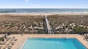 Un espace piscine offrant une vue sur la plage et l’océan.