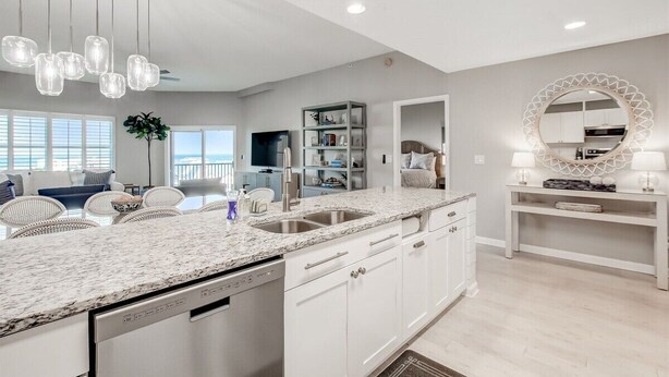 A modern kitchen with white cabinetry, a granite countertop, and pendant lighting. - Ocean Park 318 Harbor Point - Hosted By Moore AI Rentals (Fernandina Beach)