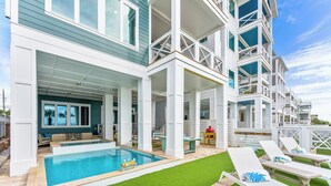 Un complexe hôtelier moderne doté d’une piscine, d’un espace extérieur aménagé et d’un patio couvert.