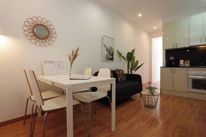 A modern living space with a dining area, a sofa, a coffee machine, and a kitchen. - 53PAR1013 - Magnifico piso en centro de Poble Sec (Barcelona)