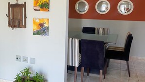 Zona pranzo con tavolo, sedie e ventilatore a soffitto.