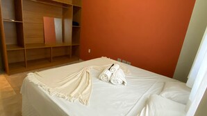 Una camera da letto con un letto, un armadio in legno e una parete decorata in rosso.