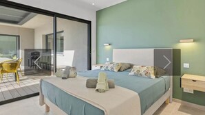 Ein modernes Schlafzimmer mit einem großen Bett, einem Schreibtisch und einem Stuhl.