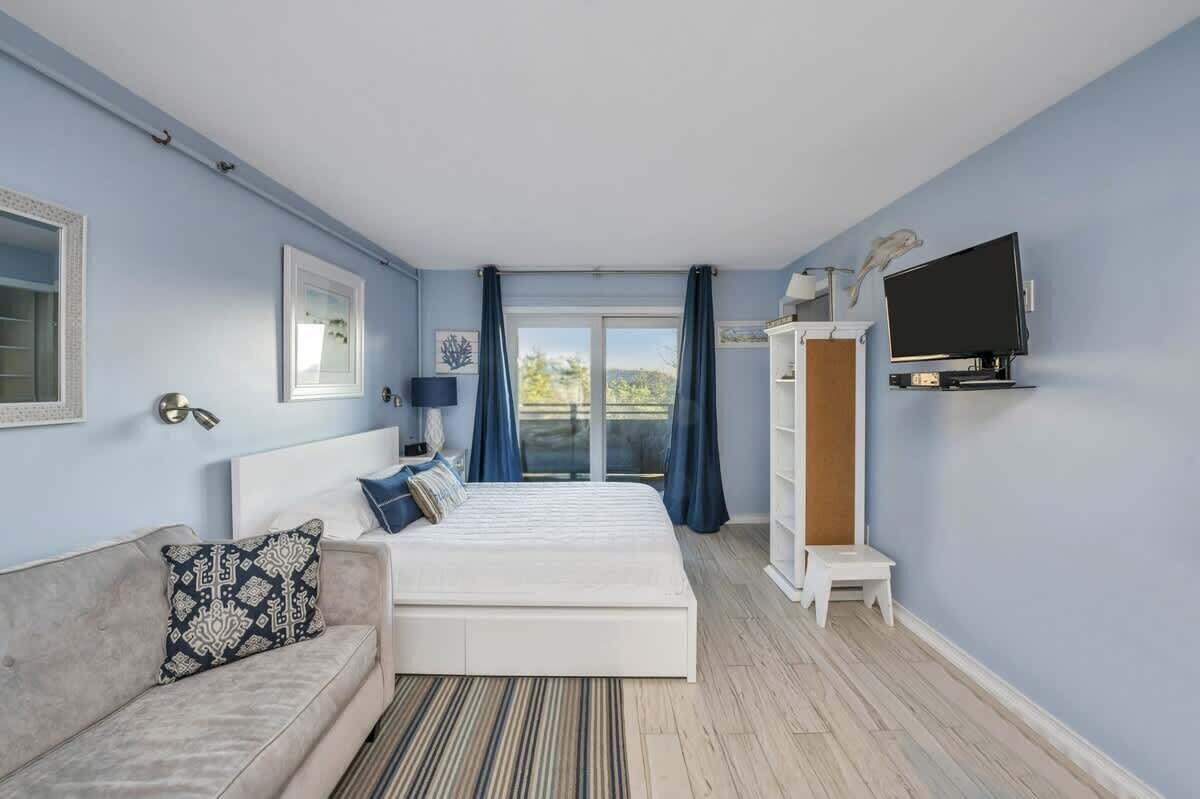 A bedroom with a bed, a sofa, a TV, and a wardrobe.