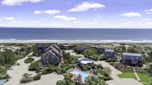 A coastal property with multiple buildings, a swimming pool, and a beach view.