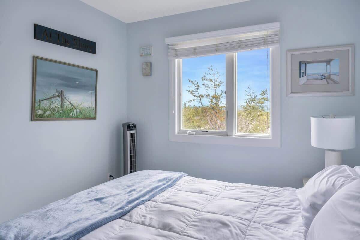 Un dormitorio con cama, ventana con vistas, radiador y decoración en la pared.