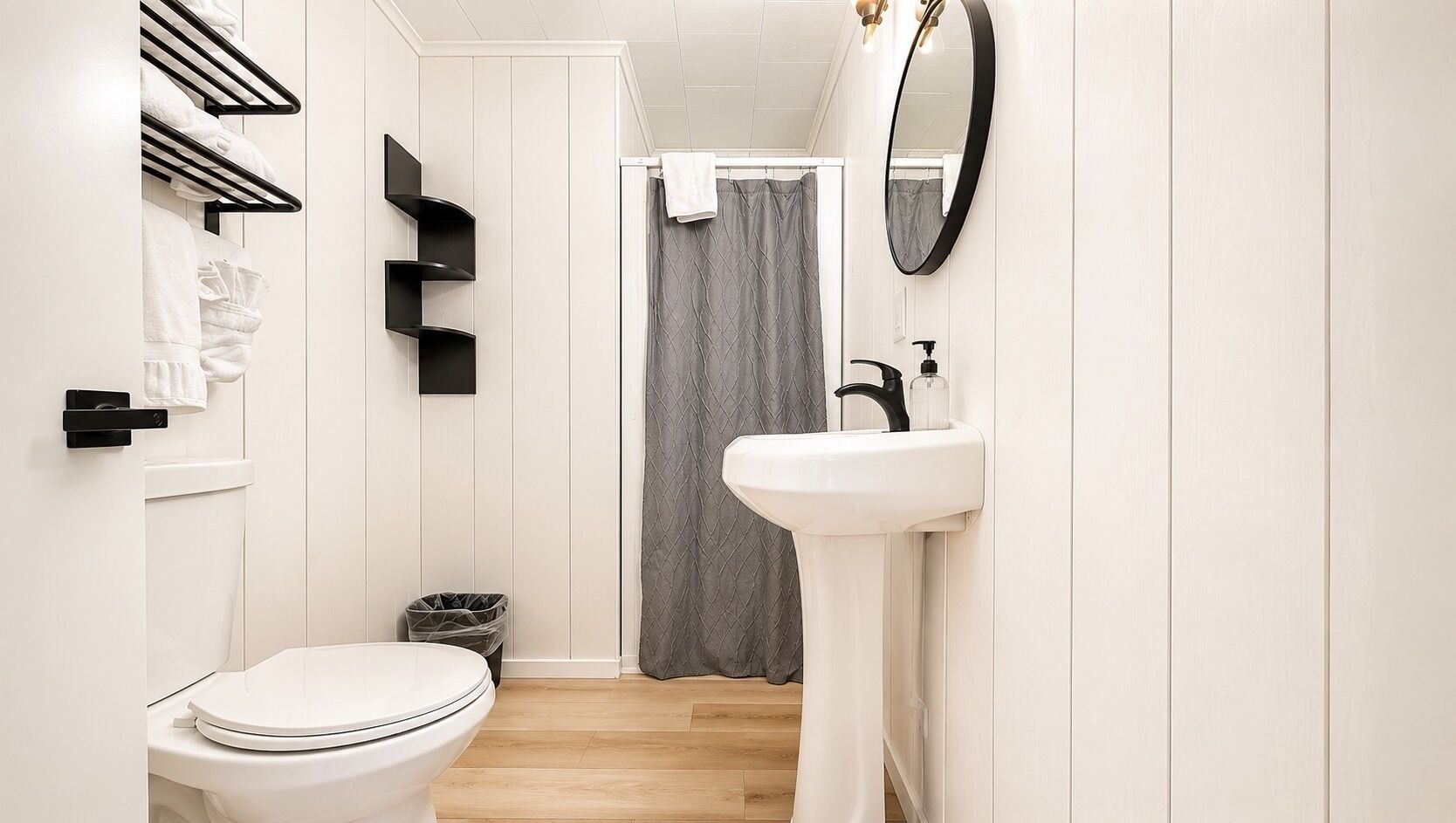 A modern bathroom with a toilet, sink, and shower curtain.