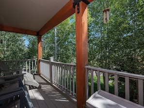 A wooden deck with a railing, overlooking a wooded area. - Mountain Laurel Condo: Porch Views, AC, Close to Music on Main (Victor)