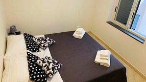A room with two beds, a window, and an air conditioning unit. - Sweet Home Catania  A (Catania)