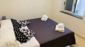 A hotel room with a bed, pillows, and a window. - Sweet Home - 101 (Catania)