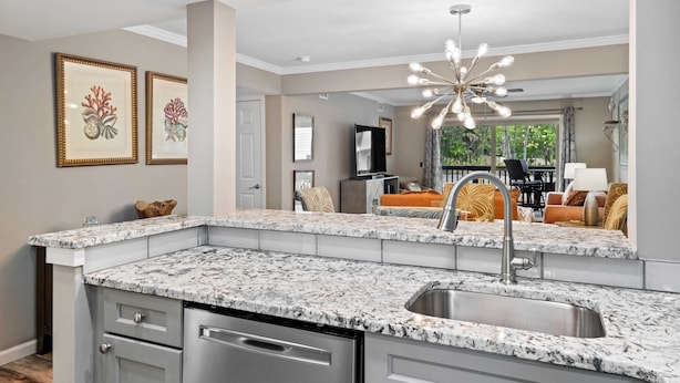 A modern kitchen with granite countertops, a stainless steel sink, and a pendant light. - Beautiful Spacious Condo w/Pool walk to Beach, Celebration Park, Coligny Plaza! (Hilton Head Island)