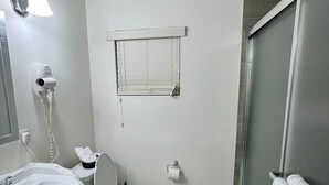 Ein Badezimmer mit Toilette, Waschbecken und Dusche.