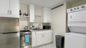 Eine moderne Küche mit weißen Schränken, Edelstahlgeräten, einer Mikrowelle und einem eingebauten Backofen.