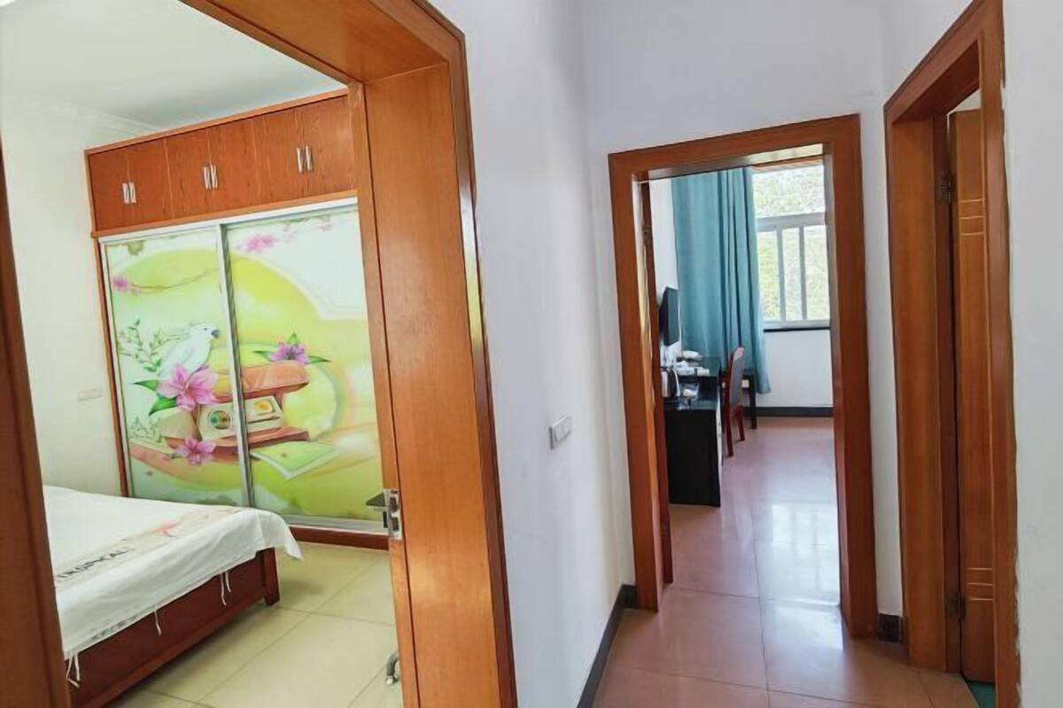 Habitació d'hotel amb un llit, un armari i vista al passadís.