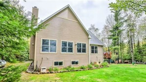 A two-story house with a gabled roof, a chimney, and a well-maintained lawn. - Beautiful Fall Foliage & Excellent Fishing on the Crown Jewel in the Northwoods (Mercer)