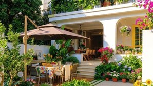 A patio with a table and chairs, surrounded by potted plants and flowers. - Yuequ Dianchi Lake Chinese Inn (Kunming)