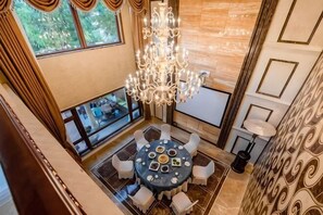 A dining area with a chandelier, a round table, and white chairs. - Yuequ Dianchi Lake Chinese Inn (Kunming)