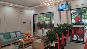 Un hall d’hôtel moderne avec un canapé, une table basse et des plantes en pot.