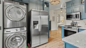 Una cocina moderna con electrodomésticos de acero inoxidable, armarios azules y una isla central con estufa.