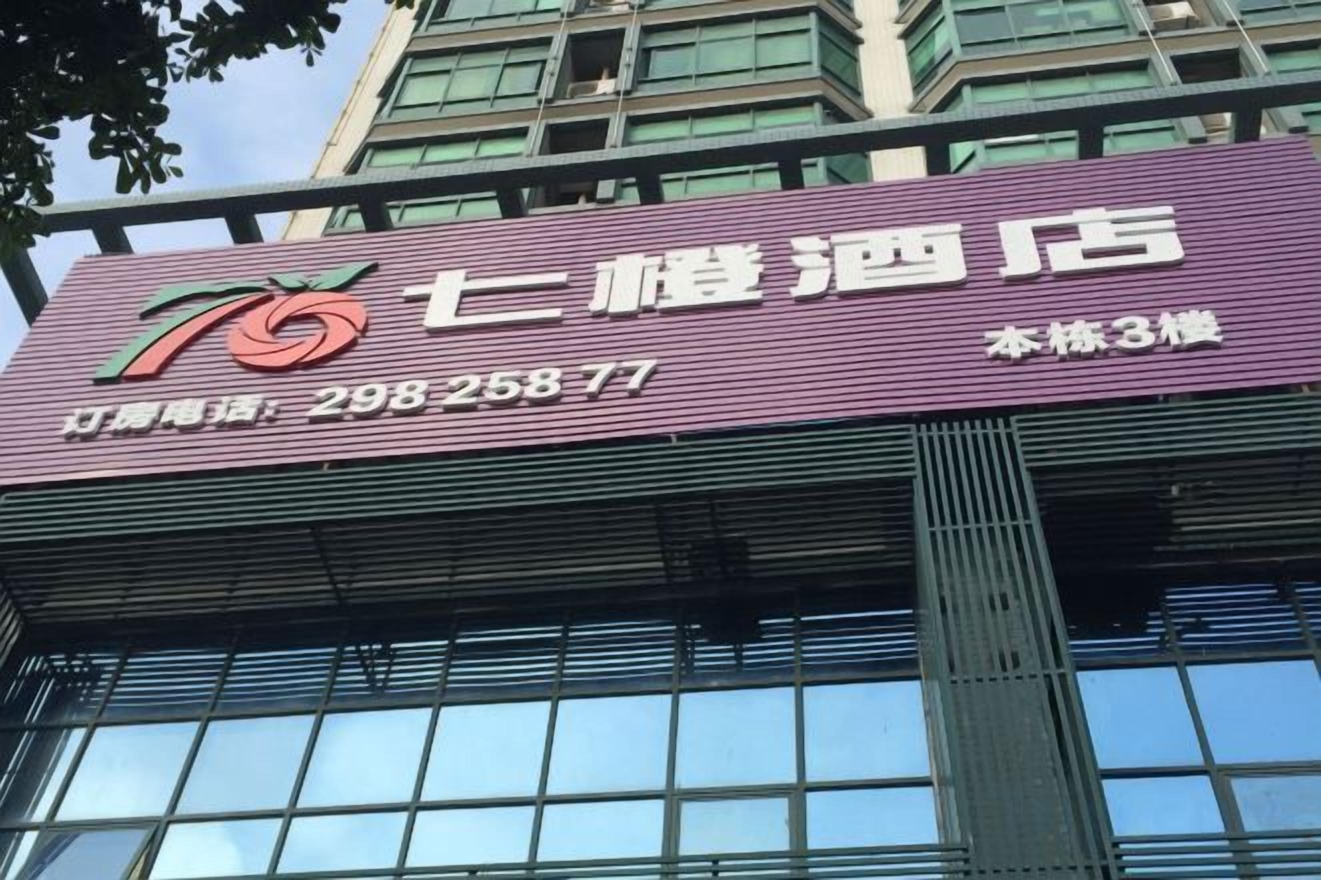 A hotel sign with a logo, name, and contact number.
