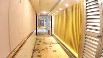 A corridor with a patterned floor, a radiator, and a door with horizontal slats.