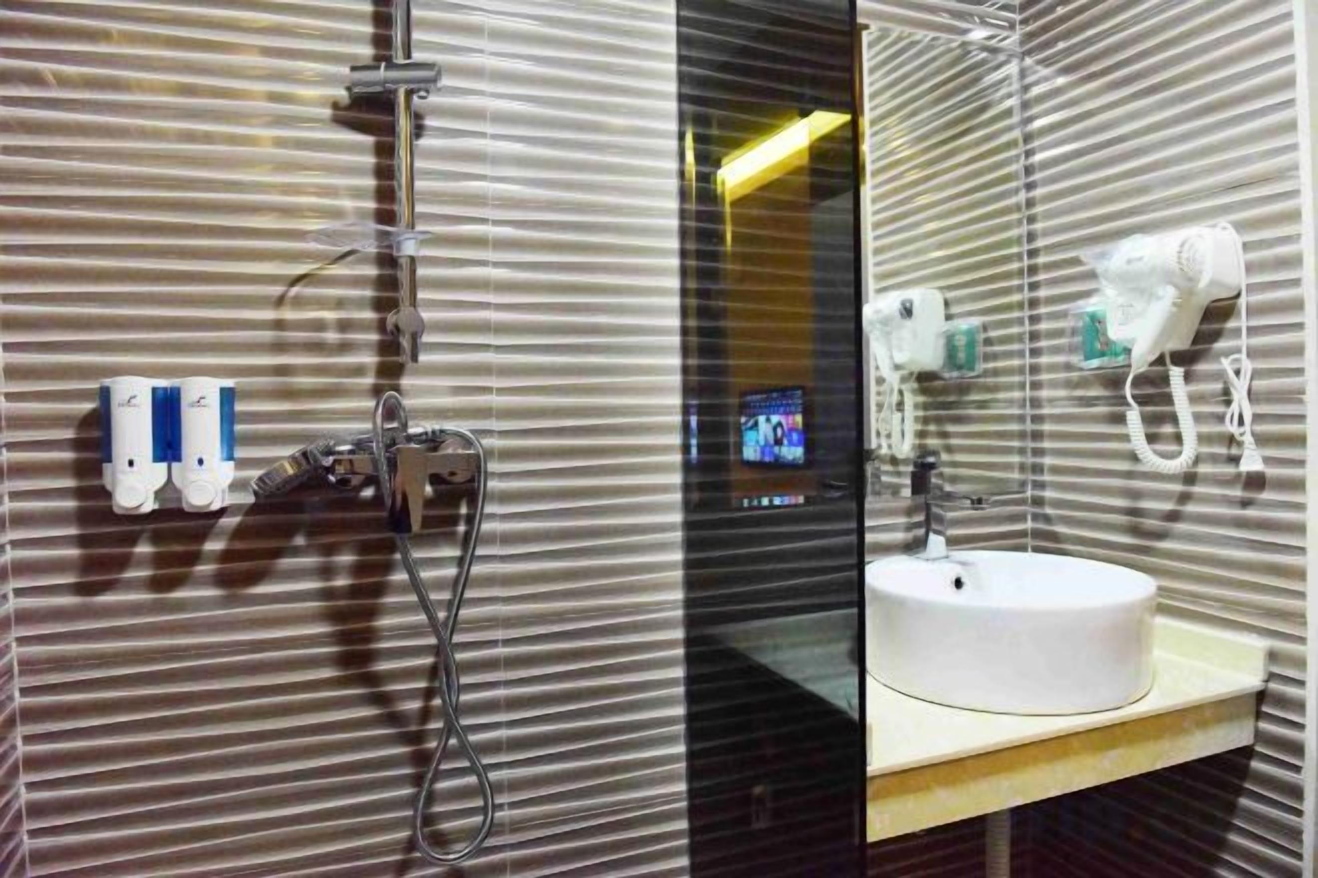 A bathroom with a shower, a sink, and a mirror.