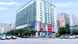 A multi-story hotel with a modern facade, featuring large windows and a prominent entrance. - Seven Orange Hotel (Shenzhen North Station Minzhi) (Shenzhen)