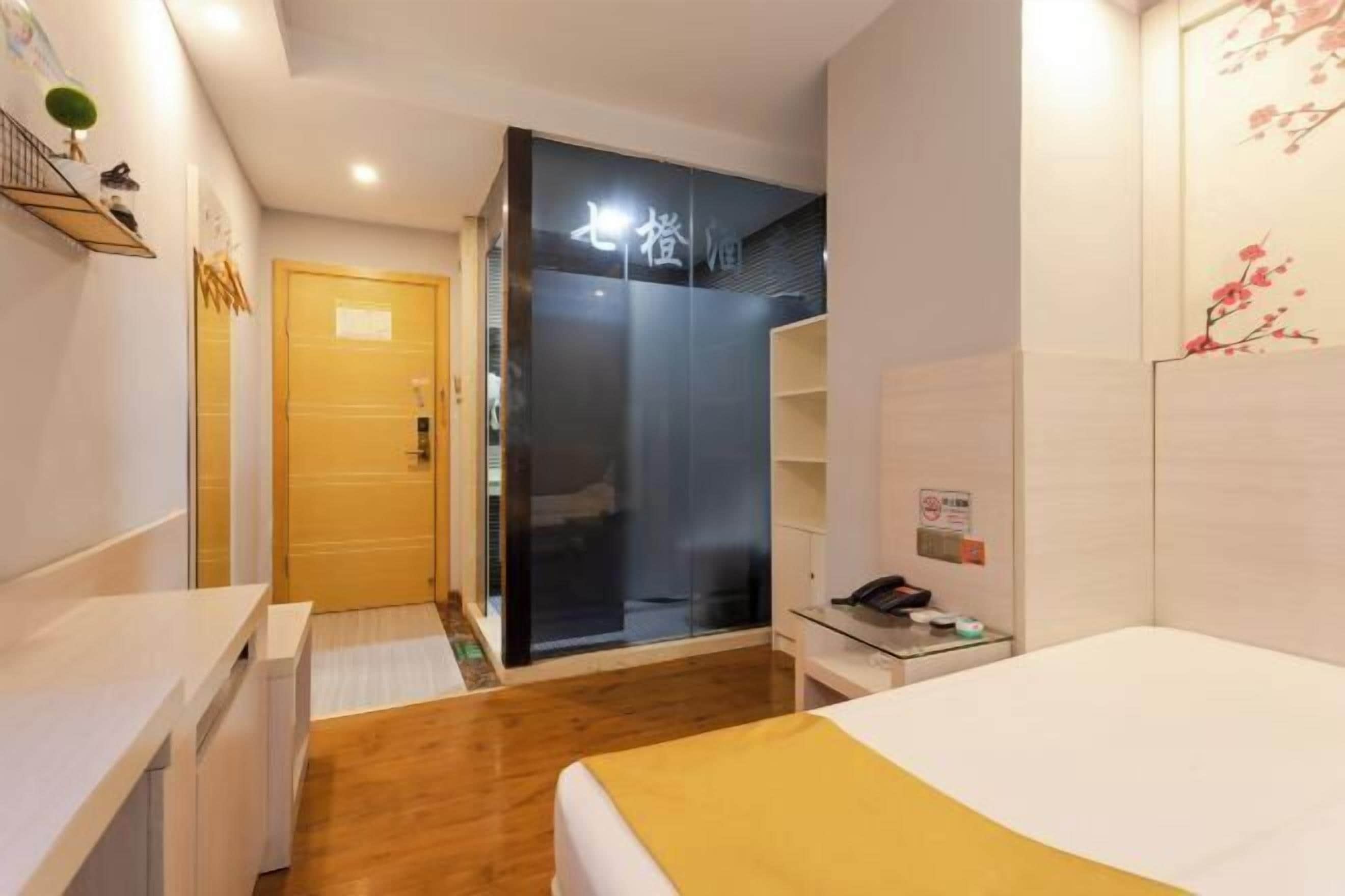 A hotel room with a bed, a desk, a wardrobe, and a sliding door closet.