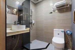 A compact bathroom with a glass shower enclosure, a white sink, and a toilet. - Seven Orange Hotel (Shenzhen North Station Minzhi) (Shenzhen)