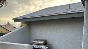 Un barbecue fixé à un mur extérieur d’une maison.
