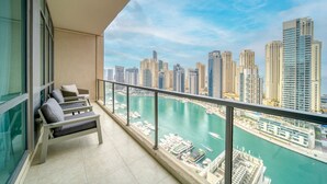 A balcony with a city view, a seating area, and a clear sky. - Alluring 2BR at Al Majara 1 Dubai Marina by Deluxe Holiday Homes (Dubai)