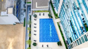 Ein modernes Gebäude mit einem blauen Swimmingpool, der mit "DAMAC" beschriftet ist.