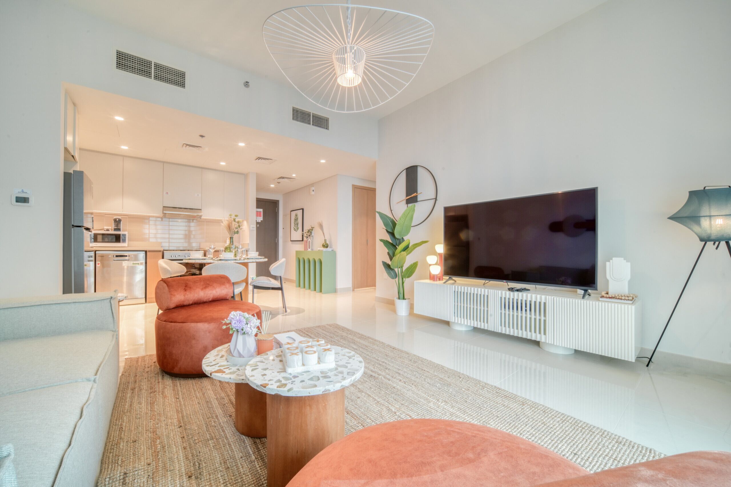 A modern living room with a sofa, coffee table, and a TV on a white stand.