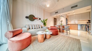 Una sala de estar moderna con un sofá, dos sillones rojos, una mesa de centro y una lámpara colgante.