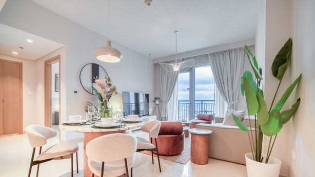 Una sala de estar moderna con comedor, ventanas amplias y una planta en maceta.
