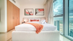 Un dormitorio moderno con una cama grande, un armario y vistas a la ciudad.