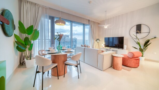 Ein modernes Wohnzimmer mit Essbereich, einer Küche und einem großen Fenster mit Blick auf die Stadt.