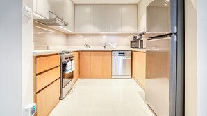 Eine moderne Küche mit Edelstahl-Kühlschrank, Einbauofen, Mikrowelle und Geschirrspüler.
