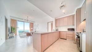 Una cocina moderna con una isla central, armarios de madera y vistas al exterior.
