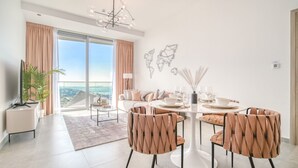 Un comedor moderno con una mesa redonda, cuatro sillas y vistas amplias a través de grandes ventanales.