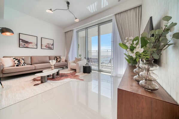 A modern living room with a sofa, coffee table, and a large window with a view.